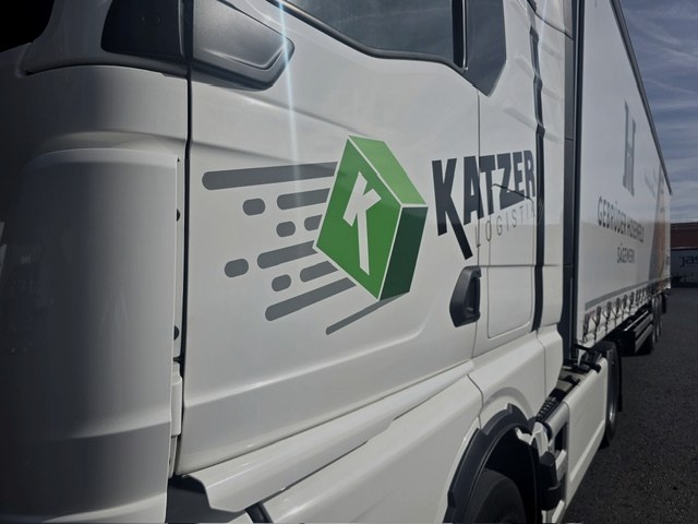 Fahrer mit Tablet vor einem modernen Katzer-LKW